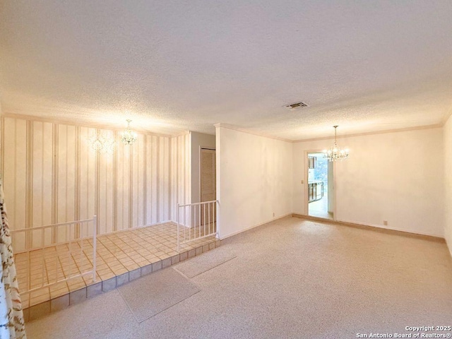 carpeted spare room with a notable chandelier and a textured ceiling