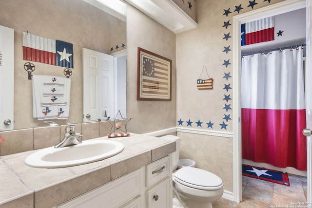 bathroom with a shower with curtain, toilet, and vanity