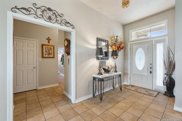 tiled entrance foyer with a textured ceiling