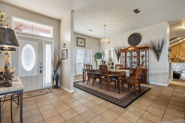 tiled foyer featuring an inviting chandelier