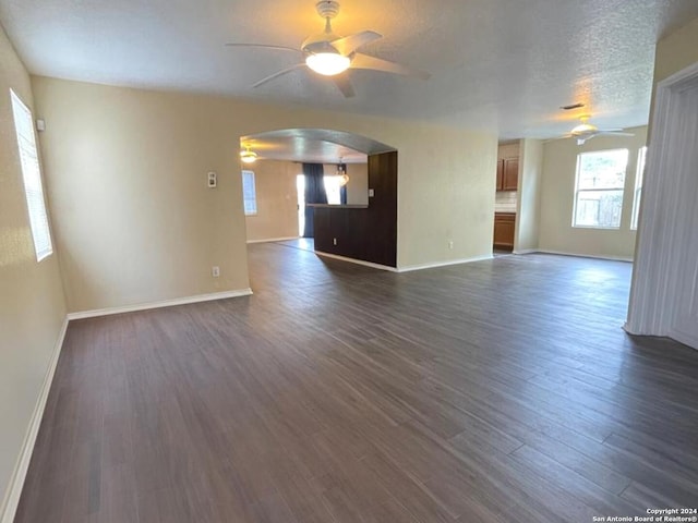 empty room featuring a textured ceiling, ceiling fan, and dark hardwood / wood-style floors