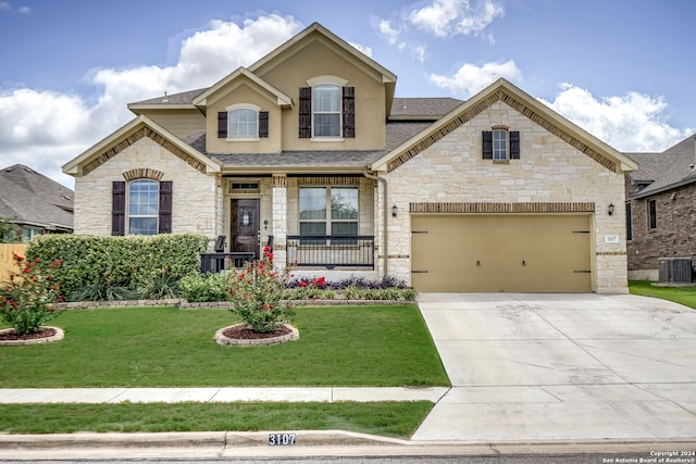 view of front of house featuring central AC, a front yard, and a garage