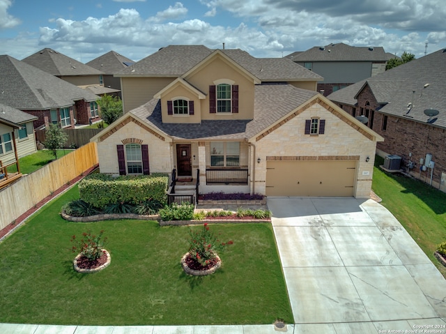 view of front of house featuring a garage, a front yard, and cooling unit