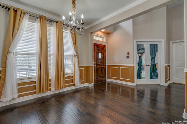 interior space with ornamental molding, french doors, dark hardwood / wood-style flooring, and an inviting chandelier