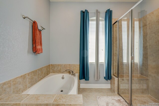 bathroom featuring tile patterned flooring, a healthy amount of sunlight, and shower with separate bathtub