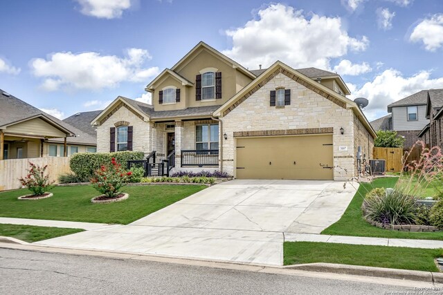 view of front of home with a garage, a front lawn, and central AC unit