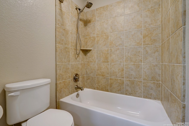 bathroom featuring tiled shower / bath and toilet