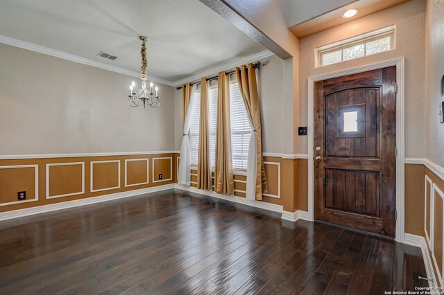 entryway featuring crown molding, dark hardwood / wood-style flooring, a healthy amount of sunlight, and a chandelier