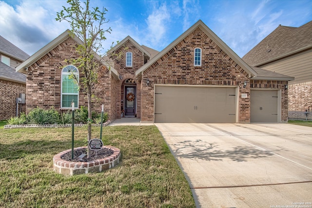 view of property featuring a garage and a front lawn