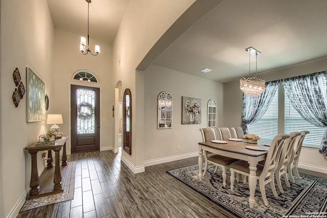 foyer entrance with a wealth of natural light, dark hardwood / wood-style flooring, and a notable chandelier