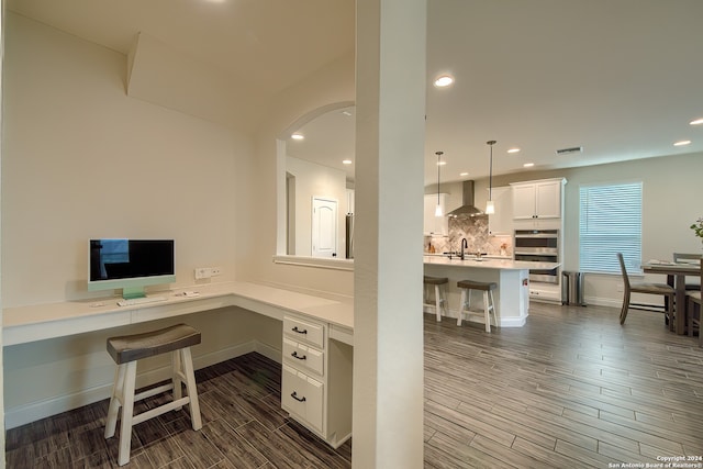 office area with built in desk, dark hardwood / wood-style flooring, and sink