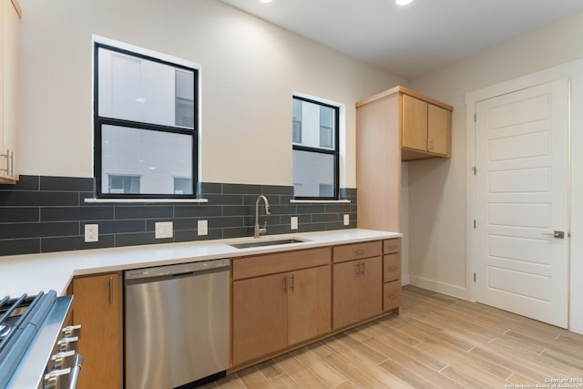 kitchen featuring stainless steel appliances, light countertops, decorative backsplash, wood tiled floor, and a sink