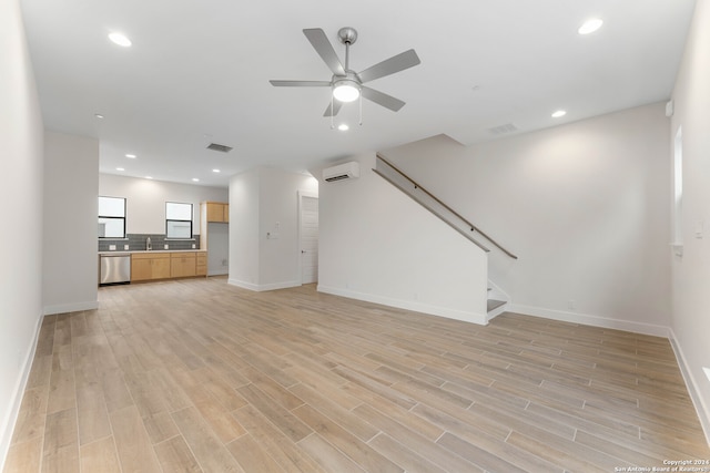 unfurnished living room featuring recessed lighting, visible vents, light wood-style floors, stairs, and a wall mounted air conditioner