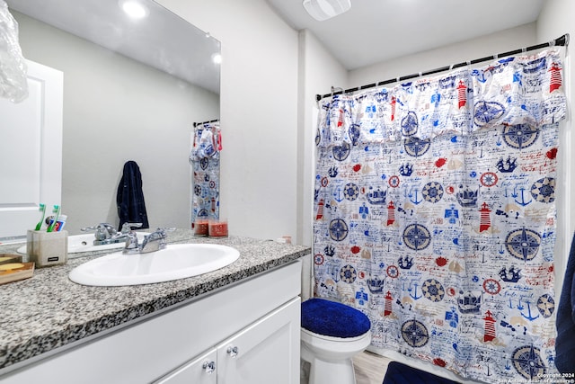 bathroom with hardwood / wood-style floors, vanity, toilet, and curtained shower