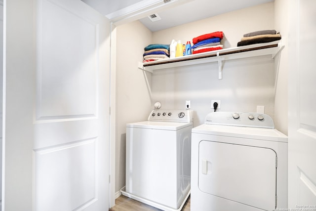 laundry room featuring light wood-type flooring and washer and clothes dryer