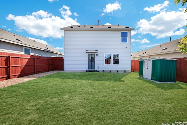 back of house featuring a lawn and a storage unit