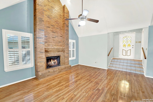 unfurnished living room featuring high vaulted ceiling, ceiling fan, a fireplace, and hardwood / wood-style flooring