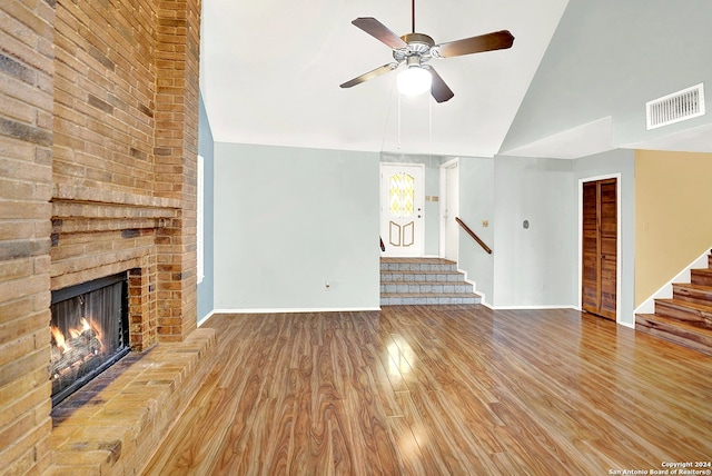 unfurnished living room with lofted ceiling, ceiling fan, light hardwood / wood-style floors, and a fireplace