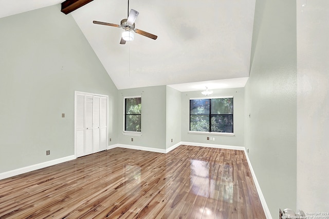 empty room featuring ceiling fan, beam ceiling, wood-type flooring, and high vaulted ceiling