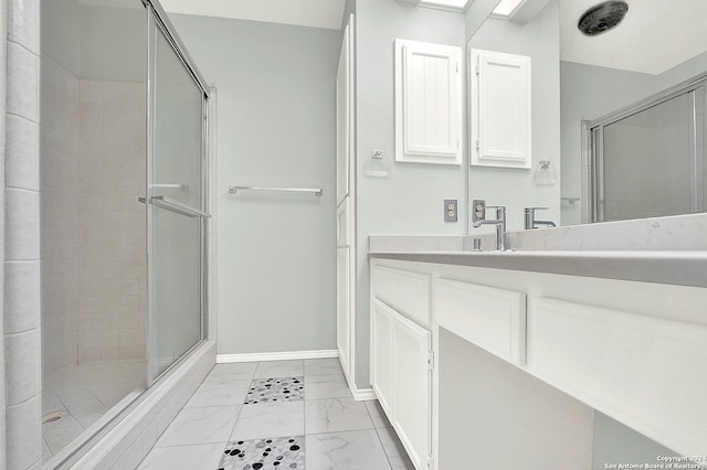 bathroom featuring vanity and a shower with door