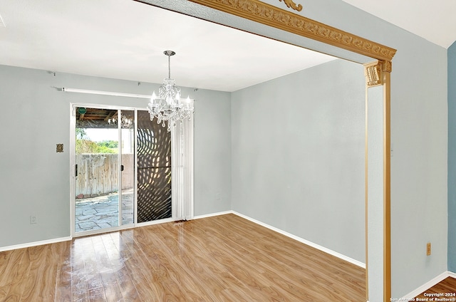 unfurnished dining area with a chandelier and hardwood / wood-style flooring