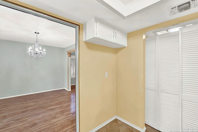 kitchen featuring decorative light fixtures, white cabinetry, and a notable chandelier