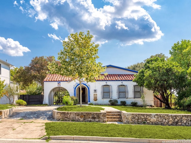 mediterranean / spanish home featuring a front lawn