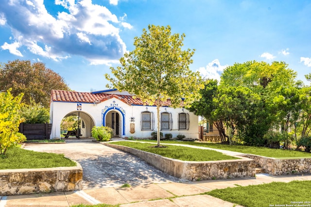 mediterranean / spanish-style house featuring a front yard