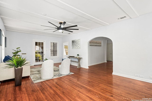 unfurnished living room featuring ceiling fan, hardwood / wood-style floors, and beam ceiling