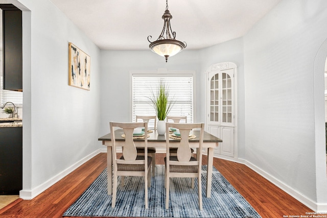 dining space with dark hardwood / wood-style flooring and sink