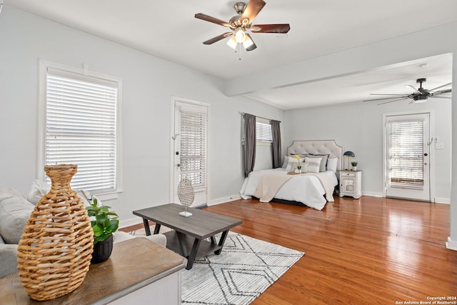 bedroom with ceiling fan, beamed ceiling, and hardwood / wood-style flooring