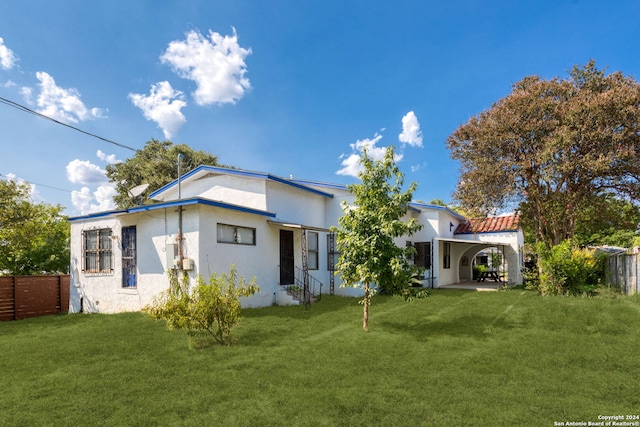 rear view of property featuring a yard and a patio area