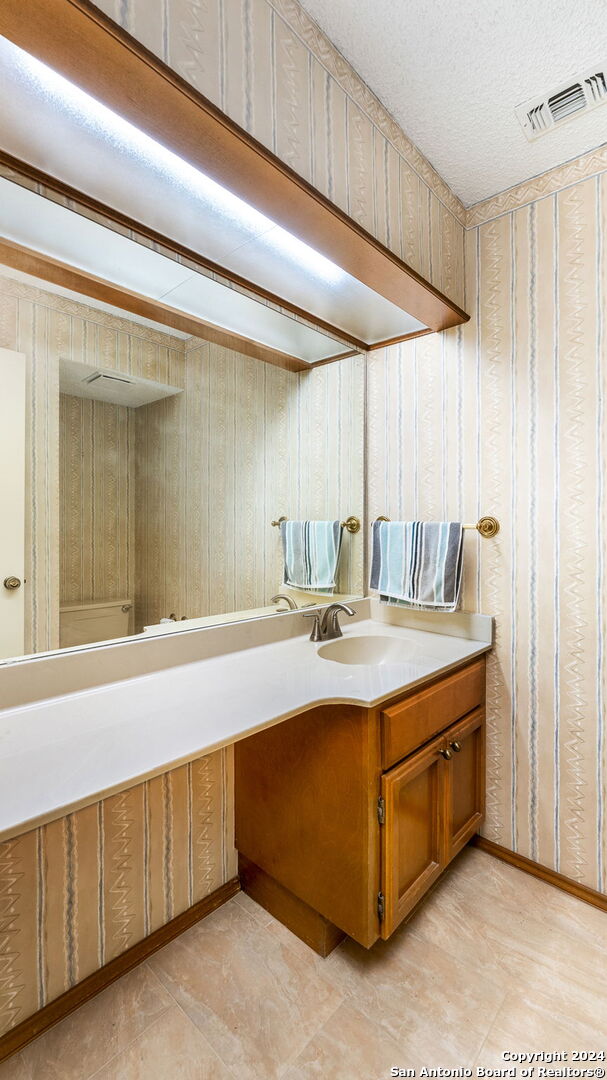 bathroom featuring a textured ceiling and vanity