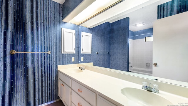 bathroom with tiled shower / bath combo and vanity