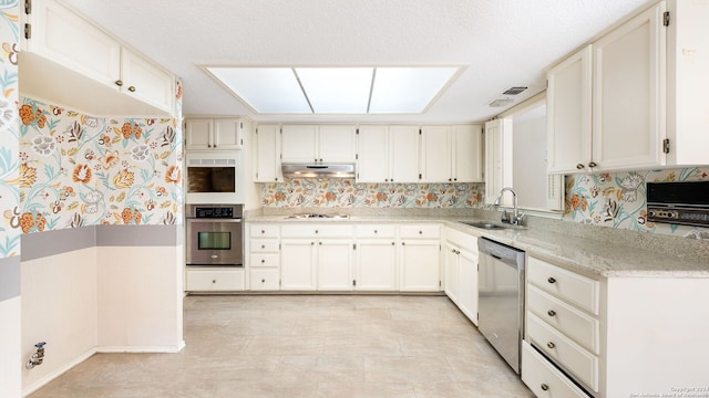 kitchen with white cabinets, appliances with stainless steel finishes, decorative backsplash, and sink