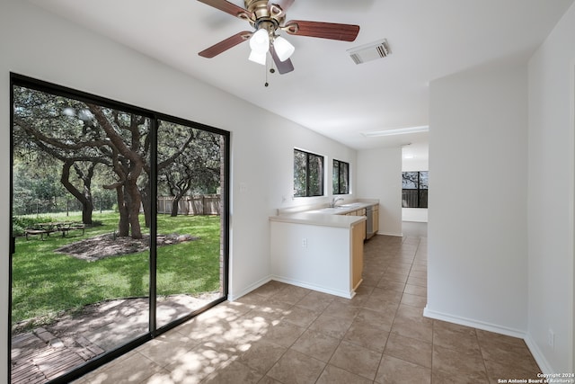 interior space featuring sink, light tile patterned floors, and ceiling fan