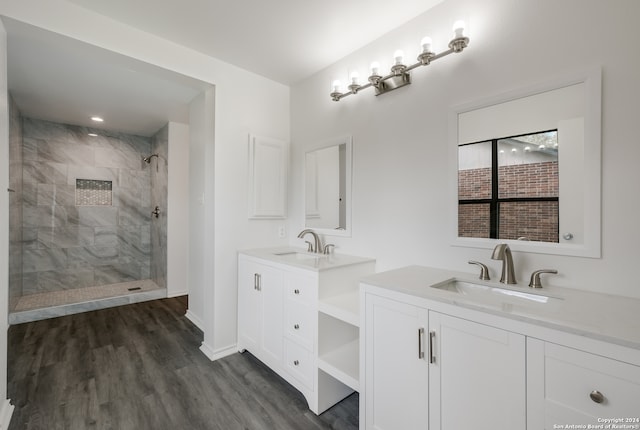 bathroom with vanity, a tile shower, and hardwood / wood-style flooring