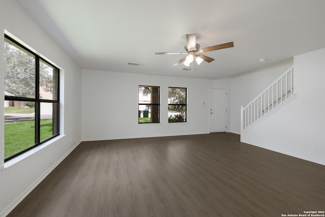 unfurnished living room featuring ceiling fan, plenty of natural light, and dark hardwood / wood-style flooring