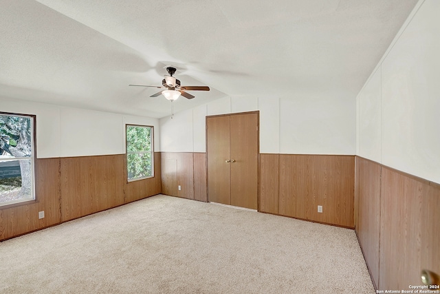 unfurnished room with a textured ceiling, a healthy amount of sunlight, ceiling fan, and light carpet