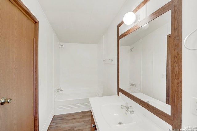 bathroom with hardwood / wood-style floors, vanity, and shower / washtub combination