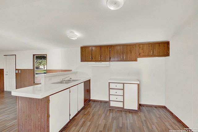 kitchen featuring light hardwood / wood-style flooring, kitchen peninsula, and sink