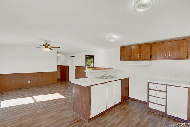 kitchen featuring ceiling fan, light hardwood / wood-style floors, kitchen peninsula, and sink