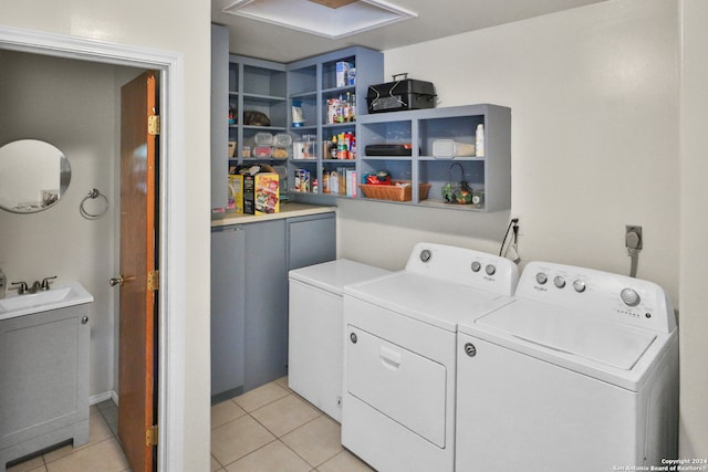 laundry room with washing machine and dryer, sink, and light tile patterned flooring