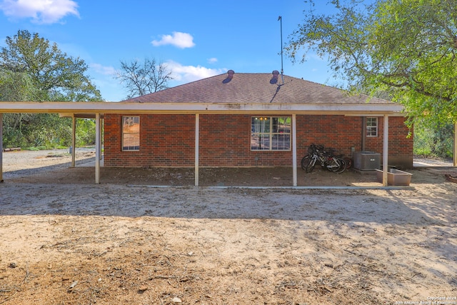 rear view of property featuring a carport and cooling unit