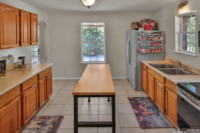 kitchen featuring light tile patterned floors, stainless steel appliances, and sink