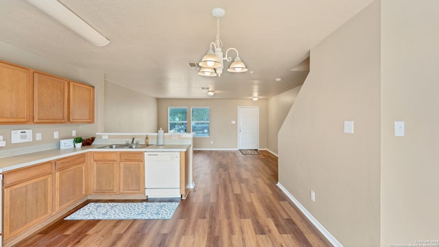 kitchen featuring an inviting chandelier, white dishwasher, wood-type flooring, hanging light fixtures, and kitchen peninsula