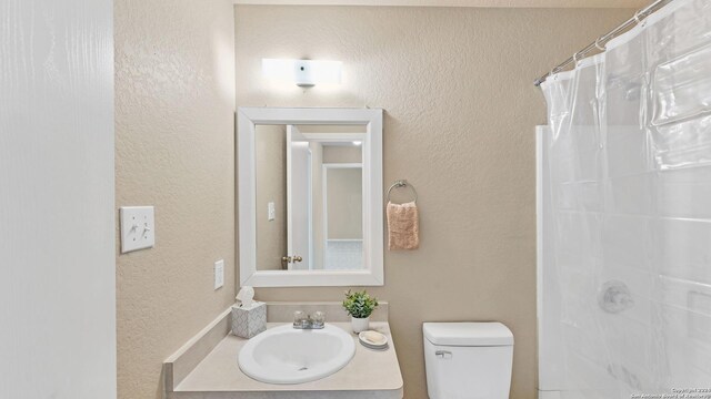 bathroom featuring vanity, toilet, and a shower with curtain