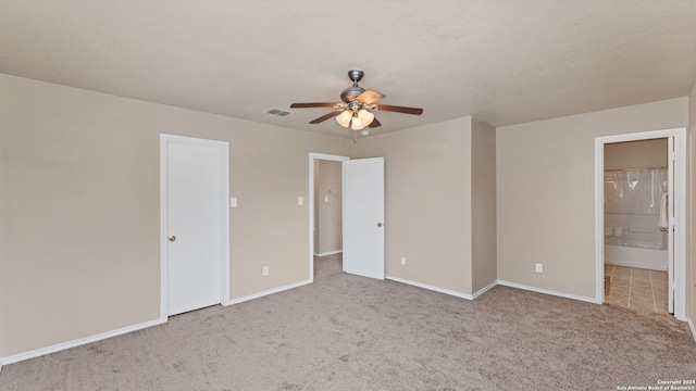 unfurnished bedroom featuring ceiling fan, ensuite bathroom, and light carpet