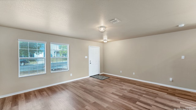 foyer entrance featuring a textured ceiling and wood-type flooring