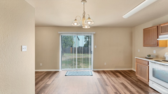 kitchen featuring hanging light fixtures, wood-type flooring, an inviting chandelier, and white electric range oven